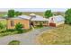 Spacious property with a stone facade, barn-style garage, and circular driveway, showcasing curb appeal at 11881 County Road 37, Fort Lupton, CO 80621