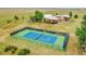 Aerial view of a well-maintained tennis court surrounded by lush greenery, offering recreational opportunities at 11881 County Road 37, Fort Lupton, CO 80621