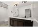 Bathroom featuring dual vanities with dark wood cabinets, white countertops, and a large mirror at 12547 Lake View St, Longmont, CO 80504