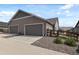 A two-car garage featuring a grey concrete driveway and decorative rock landscaping along the side of the home at 12547 Lake View St, Longmont, CO 80504
