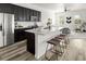 Modern kitchen island with seating overlooks the home's open concept living area at 12547 Lake View St, Longmont, CO 80504