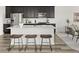 Modern kitchen features stainless steel appliances, a spacious island with seating, and dark cabinetry at 12547 Lake View St, Longmont, CO 80504