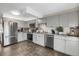 Well-lit kitchen featuring stainless steel appliances, tile backsplash, and modern gray cabinetry at 3253 S Estes St, Lakewood, CO 80227