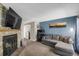 Comfortable living room features a stone fireplace, blue accent wall and gray sectional sofa at 3253 S Estes St, Lakewood, CO 80227
