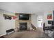 Open living area with a stone fireplace and mounted TV, adjacent to dining area and stairs at 3253 S Estes St, Lakewood, CO 80227