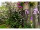 Landscaped area with lilac bushes, hanging flower basket, and purple irises against a wooden fence at 4528 W 34Th Ave, Denver, CO 80212