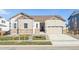 Two-story house with beige siding, a three-car garage, and a landscaped front yard at 3816 N Elk St, Aurora, CO 80019