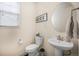 Charming powder room featuring a pedestal sink, toilet, and decorative accents at 14850 Oslo Ave, Parker, CO 80134