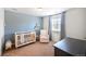 Cozy Bedroom with a crib, comfortable chair, a blue accent wall, and carpeted flooring at 14850 Oslo Ave, Parker, CO 80134