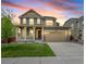 Charming two-story home with a well-maintained lawn, a covered front porch, and a two car garage at 14850 Oslo Ave, Parker, CO 80134