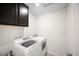 Laundry room with a side-by-side washer and dryer and ample cabinet space at 14850 Oslo Ave, Parker, CO 80134