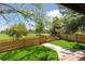 Lovely backyard featuring a gate to a community park, manicured lawn and mature trees at 1462 Marigold Dr, Lafayette, CO 80026