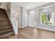 Inviting entryway with staircase, light wood floors, and a window framing the outside scenery at 1462 Marigold Dr, Lafayette, CO 80026