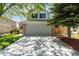 Home exterior displaying a wide driveway, stone accents, well-kept lawn, and partial view of the surrounding landscape at 1462 Marigold Dr, Lafayette, CO 80026