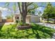 Beautifully landscaped front yard features lush green grass, a mature shade tree, and stone accents on the home's facade at 1462 Marigold Dr, Lafayette, CO 80026