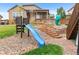 Backyard featuring play area with slide and stairs to a raised wooden deck at 17077 E 111Th Ave, Commerce City, CO 80022