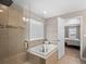 A full bathroom with a shower and tub has a window with blinds that allows natural light to enter at 17077 E 111Th Ave, Commerce City, CO 80022