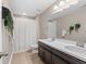 This neutral bathroom boasts a large vanity with double sinks and a shower with a white curtain at 17077 E 111Th Ave, Commerce City, CO 80022