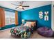 This stylish bedroom features a bright blue wall, a window, and a cozy beanbag at 17077 E 111Th Ave, Commerce City, CO 80022