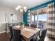 Elegant dining room with a modern chandelier and access to a private outdoor deck with comfortable seating at 17077 E 111Th Ave, Commerce City, CO 80022