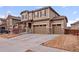 Two-story home with a three car garage, brown siding, and stone accents at 17077 E 111Th Ave, Commerce City, CO 80022