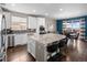 Gourmet kitchen with stainless steel appliances, gray backsplash, white cabinets, and a granite island with bar stool seating at 17077 E 111Th Ave, Commerce City, CO 80022