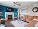 Inviting living room featuring a modern fireplace, sleek ceiling fan, and a stylish brown leather sectional sofa at 17077 E 111Th Ave, Commerce City, CO 80022