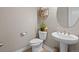 Charming powder room featuring modern fixtures, a pedestal sink, and stylish decor at 17077 E 111Th Ave, Commerce City, CO 80022