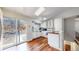 Bright kitchen features white cabinets, stainless appliances, and hardwood floors with a sliding glass door to the yard at 20091 E Bellewood Dr, Centennial, CO 80015