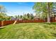 Large grassy backyard featuring a wooden fence and playground at 8022 S Jay Dr, Littleton, CO 80128