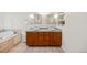 Bathroom featuring a dual sink vanity, a soaking tub, tile flooring, and neutral color palette at 8022 S Jay Dr, Littleton, CO 80128