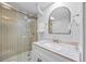Modern bathroom with a glass enclosed shower, decorative arched mirror, and stylish vanity at 8022 S Jay Dr, Littleton, CO 80128