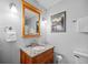 Bathroom featuring a wood vanity with a granite countertop and decorative mirror at 8022 S Jay Dr, Littleton, CO 80128