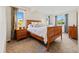 Cozy bedroom features a wooden bed frame, soft carpet, and plenty of natural light from the window at 8022 S Jay Dr, Littleton, CO 80128