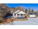 Charming home with a covered front porch and snow covered lawn at 202 Lower Glenway St, Palmer Lake, CO 80133