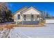 Charming, two-story house with a welcoming front porch and a detached garage with snow covering the ground at 202 Lower Glenway St, Palmer Lake, CO 80133