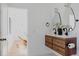 Bathroom with wood vanity has double sinks, black fixtures and view of lounge area at 2415 Urban St, Lakewood, CO 80215