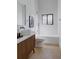 Bright bathroom features single vanity, vessel sink, a window over the tub, and modern fixtures at 2415 Urban St, Lakewood, CO 80215