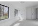 Bright, empty bedroom features white walls, carpet, two windows, and white doors at 2415 Urban St, Lakewood, CO 80215