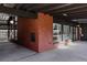 An open carport area, blending brick walls, modern grid elements, and views into a sunlit living space at 2415 Urban St, Lakewood, CO 80215