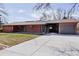 Striking home showcases a long concrete driveway and a unique brick facade with modern architectural details at 2415 Urban St, Lakewood, CO 80215