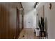 Bright hallway features hardwood floors, wood-paneled walls, and modern lighting fixtures at 2415 Urban St, Lakewood, CO 80215