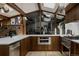 Open kitchen featuring stainless steel appliances, wooden cabinetry, and modern lighting fixtures at 2415 Urban St, Lakewood, CO 80215