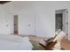 Main bedroom with hardwood floors has a chair and a view of the main bathroom at 2415 Urban St, Lakewood, CO 80215
