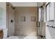 Walk-in shower features neutral tile and black fixtures at 2415 Urban St, Lakewood, CO 80215