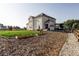 Spacious backyard with a playset, garden beds, and modern two-story house featuring solar panels on the roof at 1221 W 144Th Ct, Westminster, CO 80023