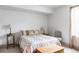 Neutral bedroom with a decorative bedspread, side tables with lamps, and a gray chair at 1221 W 144Th Ct, Westminster, CO 80023