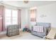 Cozy Bedroom features a crib, changing table, neutral carpet, and a bright window at 1221 W 144Th Ct, Westminster, CO 80023