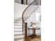 Elegant curved staircase featuring wood and iron accents, complemented by a stylish round table with decorative items at 1221 W 144Th Ct, Westminster, CO 80023