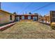 Backyard features overgrown grass, a brick border, a wooden deck, and a view of the back of the house at 7146 Jennie Dr, Denver, CO 80221